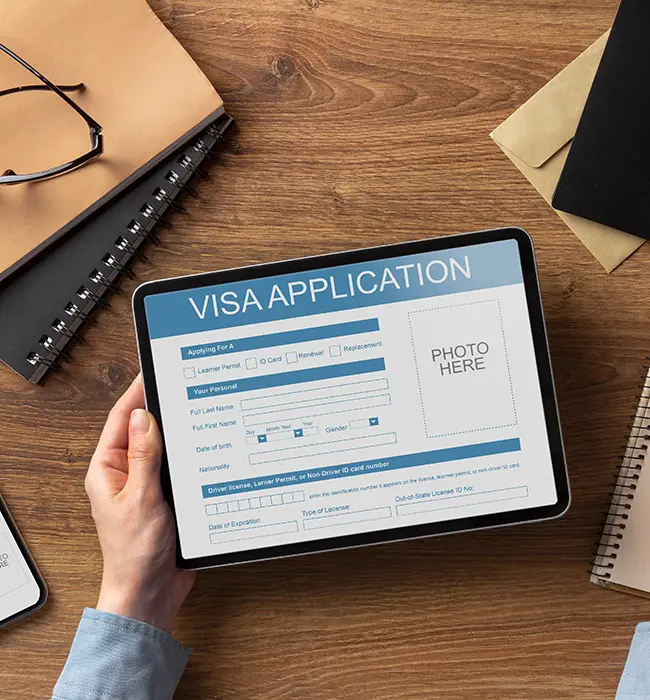 a hand holding visa application in a tablet
