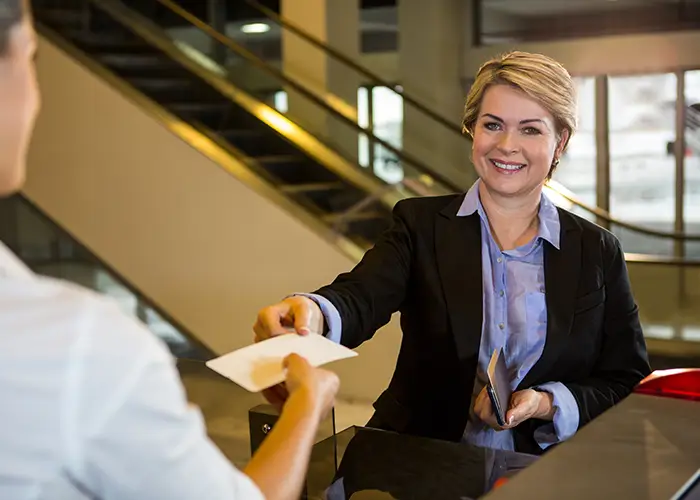 lady traveller shows her passport and boarding pass to the airport officials