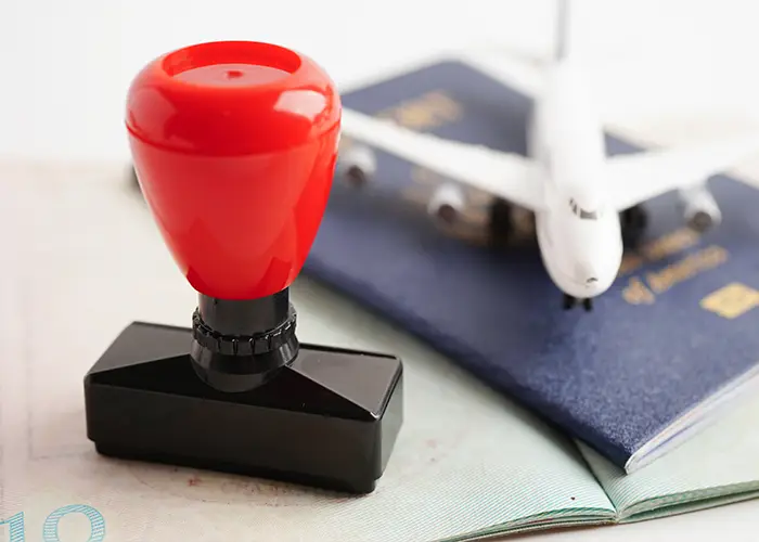 A red seal stamp on a passport with a model airplane in the background.