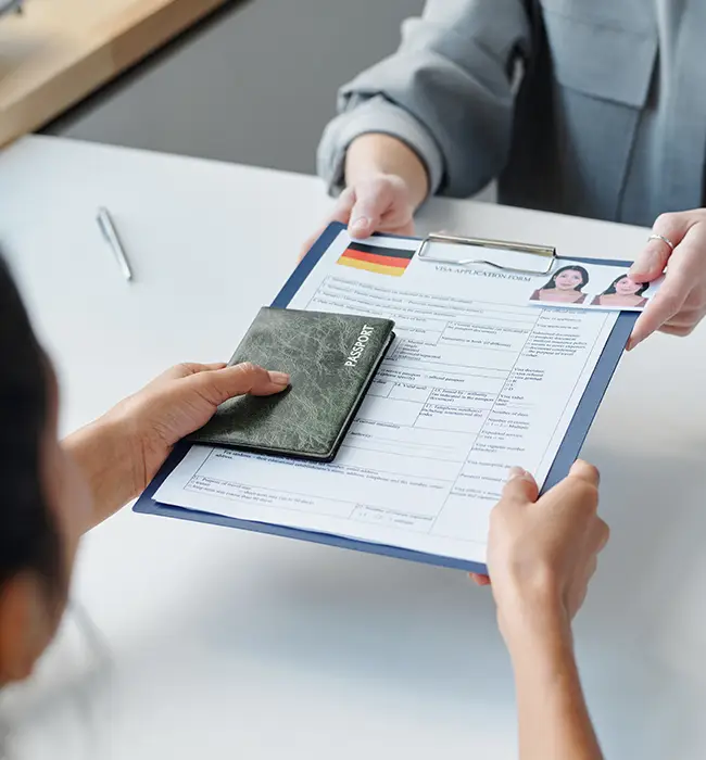 Person handing over a passport while holding a visa application form.